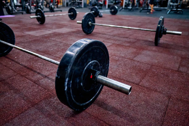 barbo sul pavimento nella scatola di addestramento incrociato. concetto di cross training, qualificazioni online per i campionati di cross training - crouching barbell weightlifting weight training foto e immagini stock