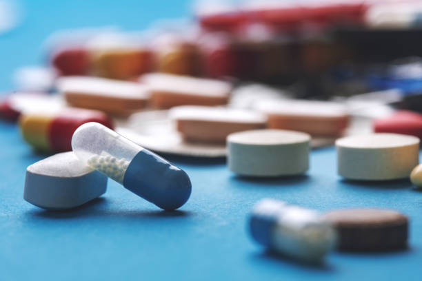istock Vitamins, dietary supplements, drugs, tablets pills and capsules on blue background. 1192055510
