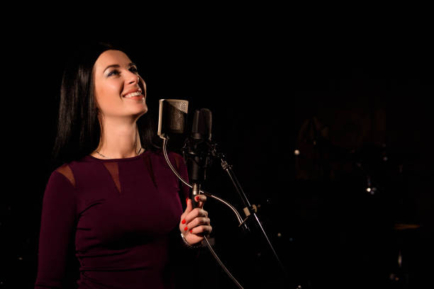 istock Singer recording a song in music studio. 1192056341