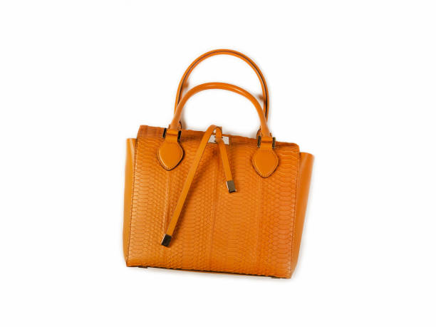 istock Yellow women bag made of python skin with handles lies on its side top view 1192058364