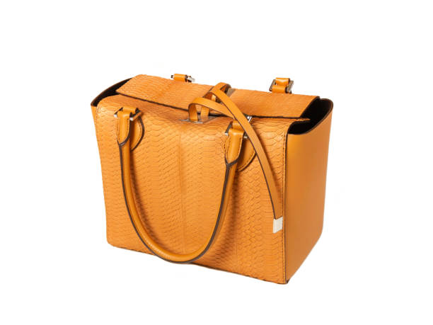 istock Yellow women bag made of python skin on a white background half side 1192058368