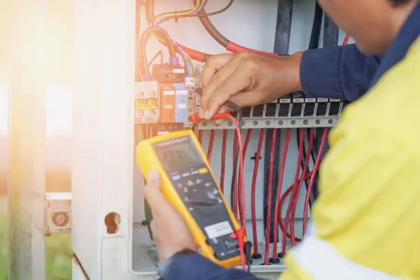 Workers use a Multimeter to measure the voltage of electrical wires produced from solar energy to confirm systems working normally.