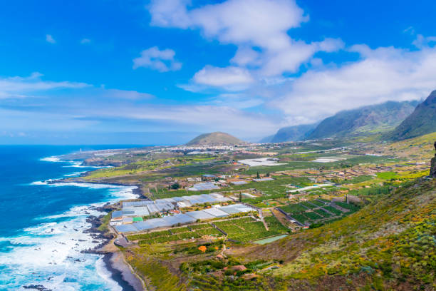 Panoramic view of Buenavista del Norte valley with volcanic crater in the middle and Teno mountains on the right, Tenerife, Canary Island, Spain Buenavista is the last northern town in Tenerife, the road ends here, beyond which all you find is the rocky fortress of the Teno Mountains. teno mountains photos stock pictures, royalty-free photos & images