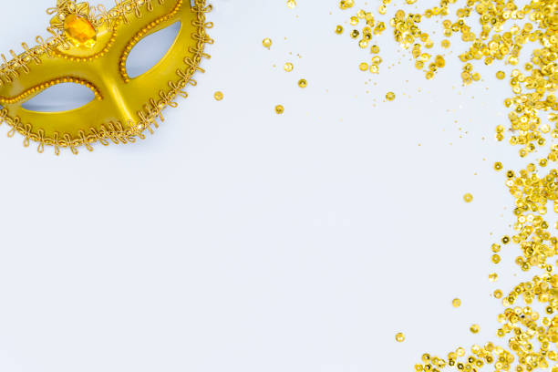 Carnival golden mask with confetti on white background. Creative New Year, festive composition flatlay. Christmas background, flat lay, top view, copyspace