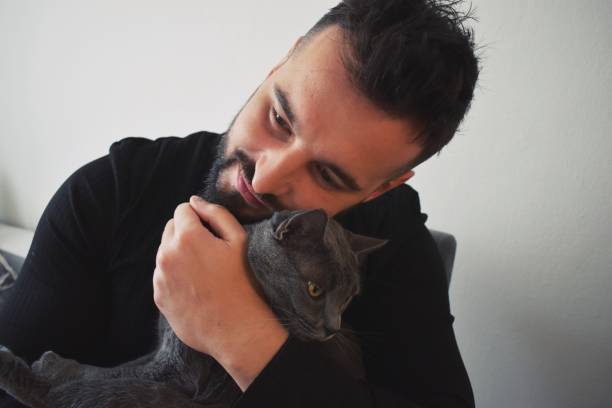 istock Man indoors hugging his cat 1192064644