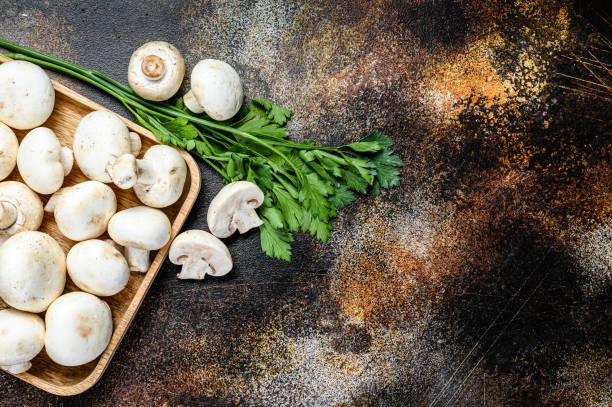 istock mushroom champignon in a bamboo bowl. Dark background. Top view.  Space for text 1192065848