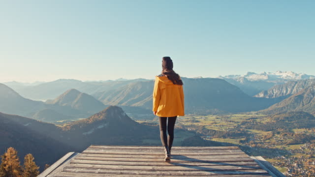 MS Young woman walking to edge of platform overlooking sunny, scenic mountain landscape view, Loser Mountain, Austria