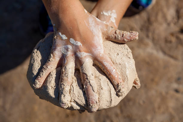 istock The child holds wet sand by hands 1192068503