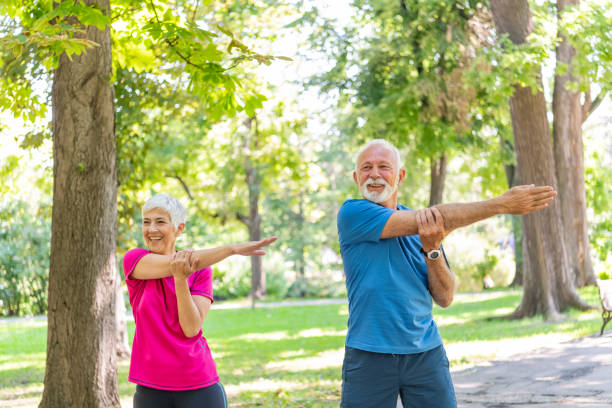 istock Mature Couple is Doing Warm-up Exercise in Public Park 1192069028
