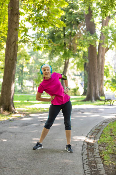 istock Senior Woman is Doing Warm Up Exercise in Nature 1192069311