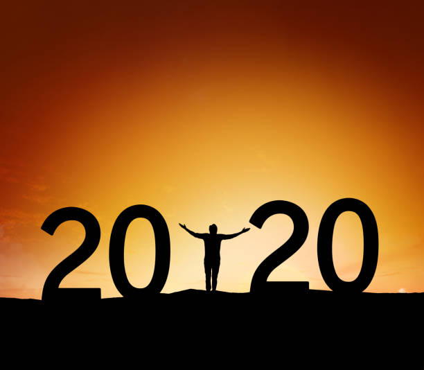 istock 2020, silhouette of a successful man standing at hill raising hands 1192070111