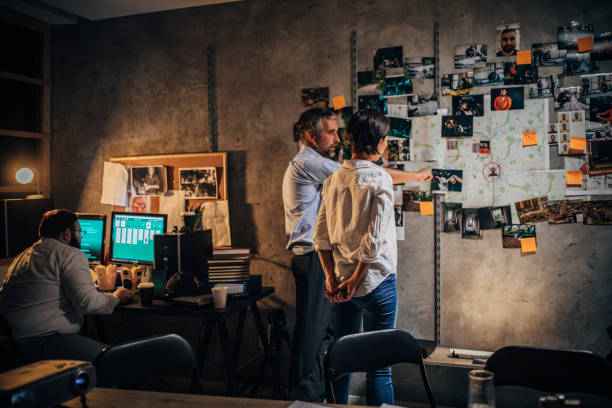 Three detectives working together in office Three people, two men and one woman, detectives and FBI agents working together on a case in dark office. sergeant badge stock pictures, royalty-free photos & images