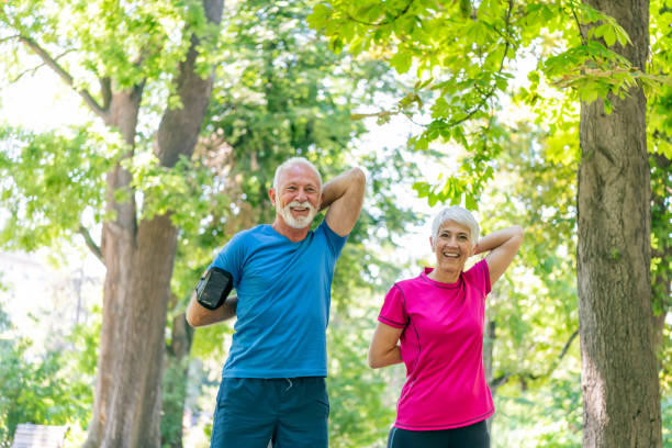 istock Active Senior Couple is Stretching Outdoors in Nature 1192070290
