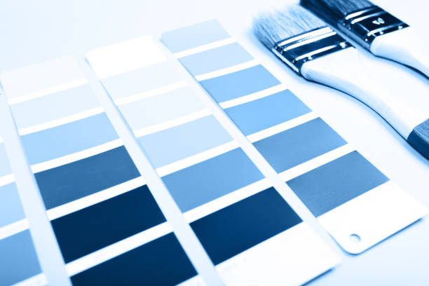 istock Two paint brush laying on heap of color samples. 1192070380