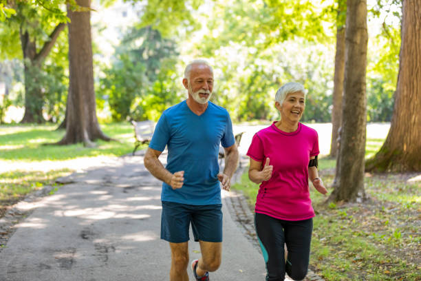 istock Active Senior Couple is Jogging Outdoors in Nature 1192070383