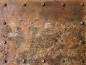 Grungy old multi-colored rusted and patina covered abstract metal plate background with bolts surrounding the plate on the edges, lots of eroded character.