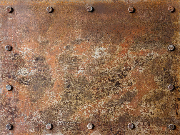 Grungy old multi-colored rusted and patina covered abstract metal plate background with bolts surrounding the plate on the edges, lots of eroded character. stock photo
