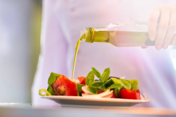 istock Mature chef pouring apple cider vinegar on salad in plate at kitchen 1192072863