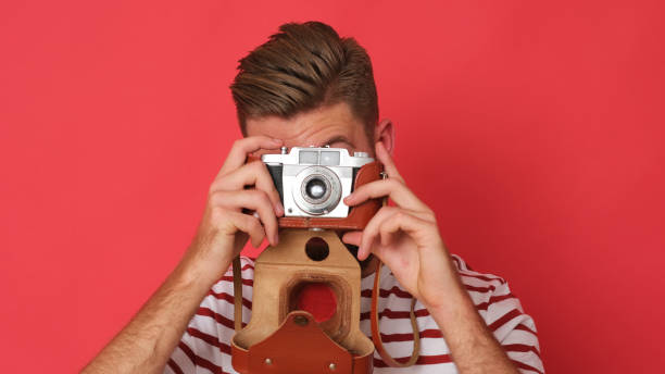 istock Close up of man with beard taking a picture by old-fashioned camera. 1192076110