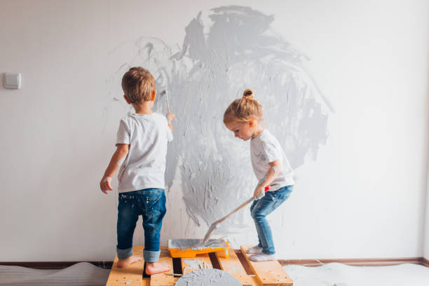 istock Twin siblings paint the wall in their room 1192076241