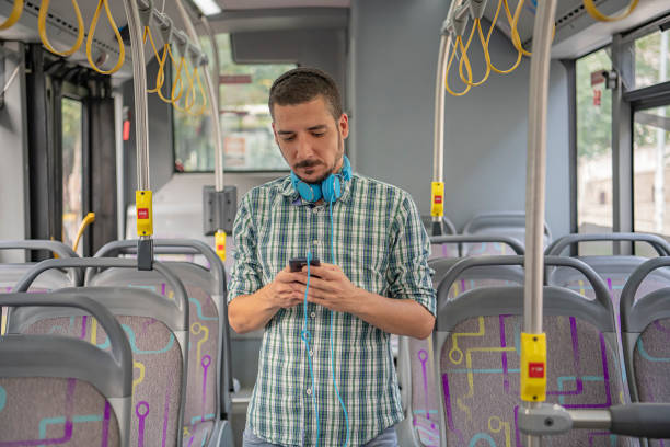 istock Handsome Man is Standing in Public Bus and Using his Smartphone 1192079067