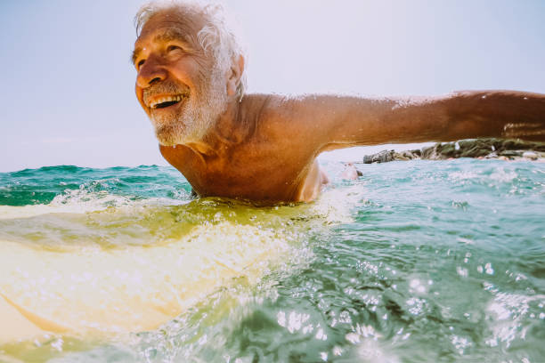 istock Senior man surfing in the sea 1192079746