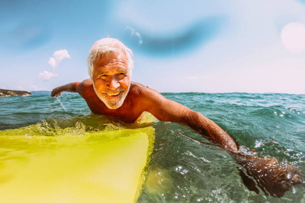 istock Senior man surfing in the sea 1192079775