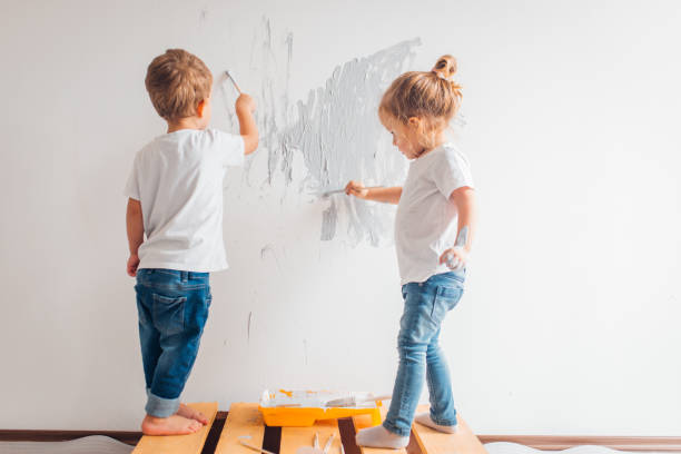 istock Twin siblings paint the wall in their room 1192080124