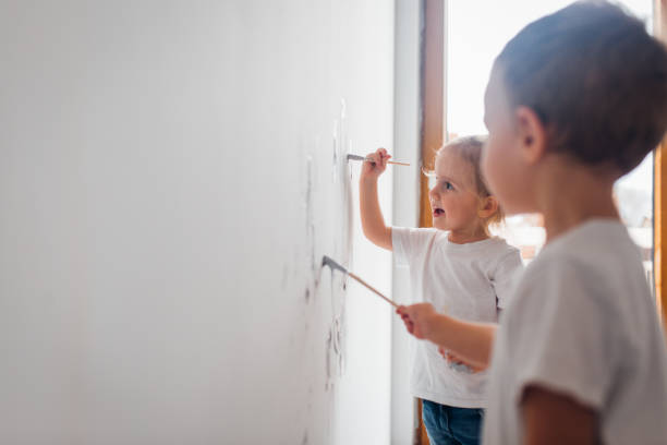 istock Twin siblings paint the wall in their room 1192080340