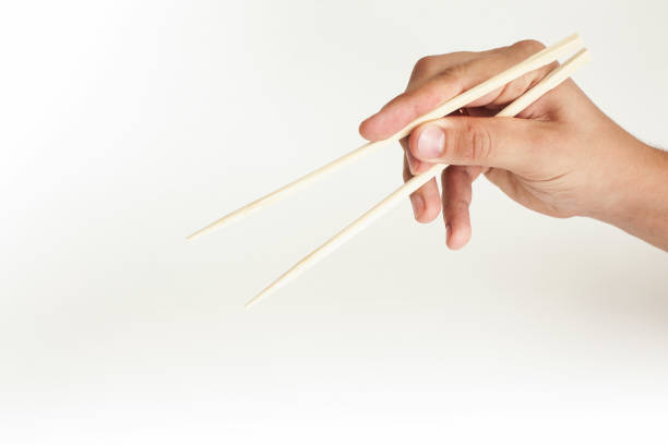 istock Hand on a white background holds sushi sticks 1192080512