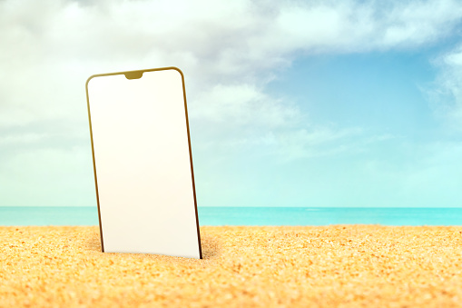 Mobile phone in the sand on the beach. Summer Concept.