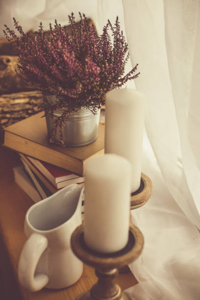 istock Flowers, books, and candles by the window 1192083097