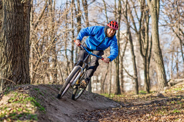 istock Cyclist in a blue jacket riding a bike on a forest path. 1192083114