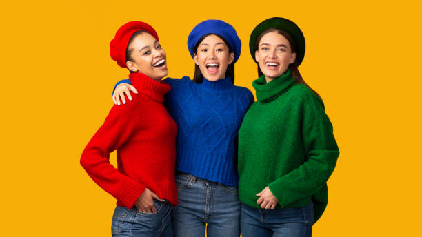 Best Friends. Three Happy Multiethnic Girls Embracing Smiling At Camera Standing In Studio Over Yellow Background. Panorama