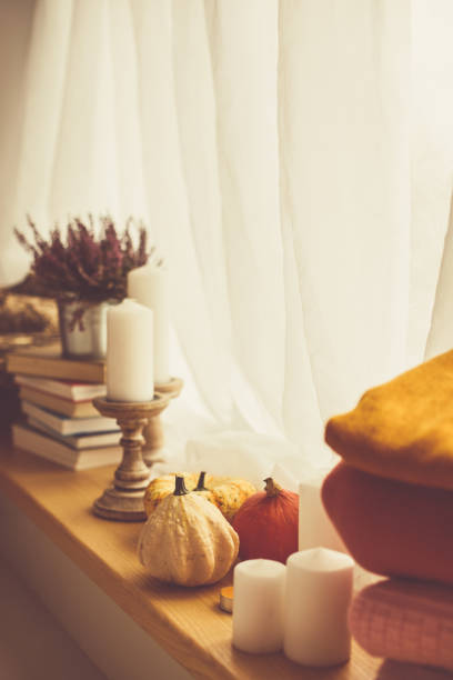 istock Books, candles and autumn decor by the window 1192084138