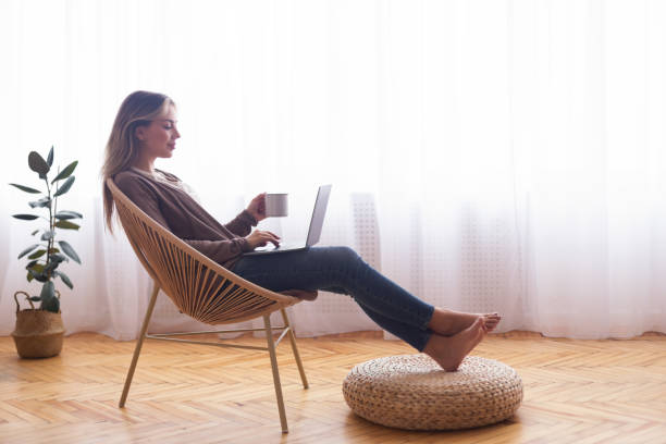 Young girl networking on laptop, relaxing with coffee
