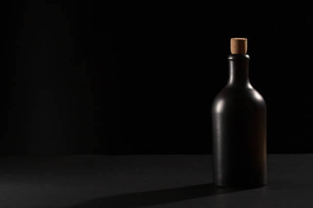 elegant black bottle of whiskey or rum on a black background. - brandy bottle alcohol studio shot imagens e fotografias de stock
