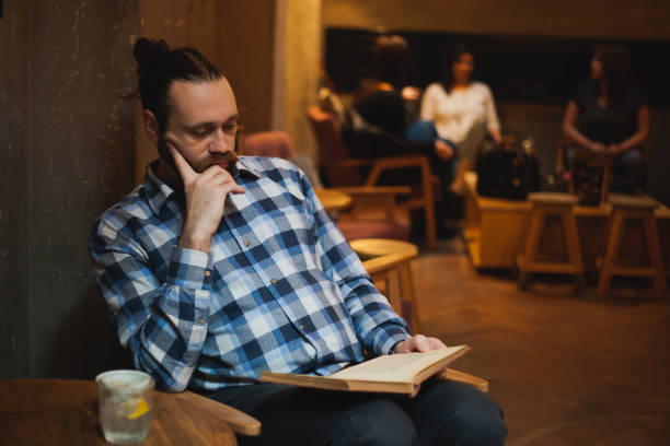 istock Man reading a book at cafe 1192086462