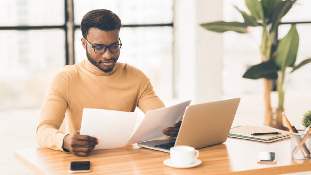 istock African american manager checking reports in modern office 1192087865