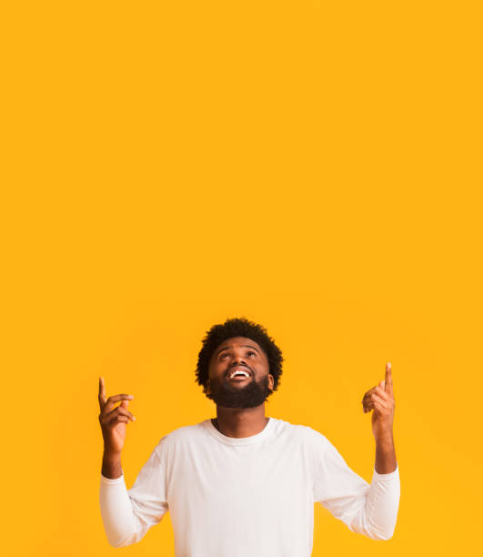istock Positive afro man looking and pointing up at free space 1192088518