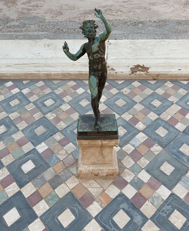 Dancing faun statue in the house of the faun of Pompeii (Pompei). Ancient Roman city in Pompei, Province of Naples, Campania, Italy