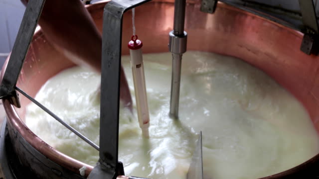 Farmer Mixing and Heating Goat Milk To Make Cheese