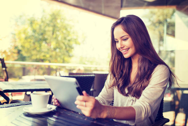 istock Young woman in cafe  using tablet 1192089419
