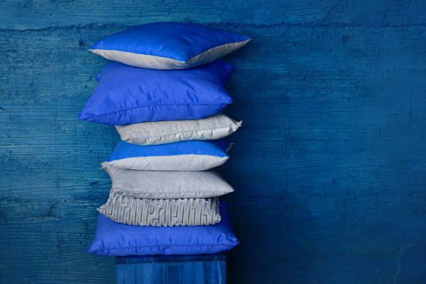 pillows on chair against blue wall. - scandic imagens e fotografias de stock