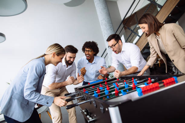 istock Happy young office workers playing table football 1192090018