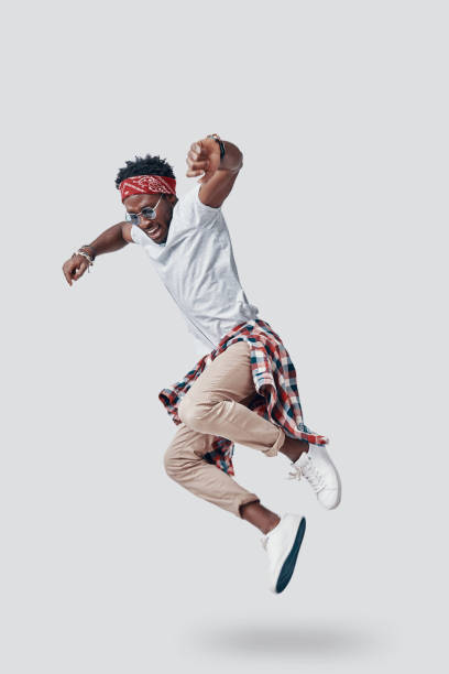 istock Full length of playful young African man smiling while hovering against grey background 1192090449