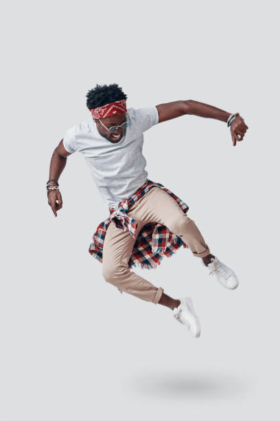 istock Full length of playful young African man smiling while hovering against grey background 1192090506