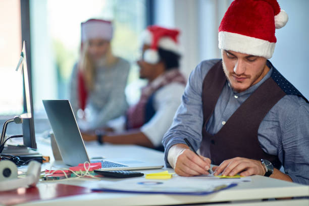 istock Working at Christmas at office. Man work in office in xmas. 1192090630