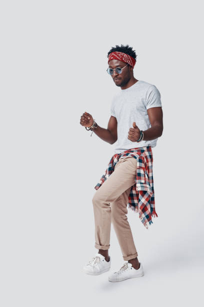 istock Full length of playful young African man dancing while standing against grey background 1192091204