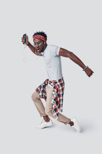 istock Full length of handsome young African man dancing and making a face while standing against grey background 1192091382